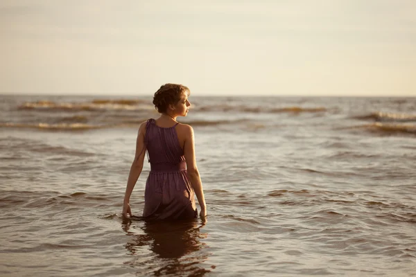 Femme sur la plage au coucher du soleil. — Photo