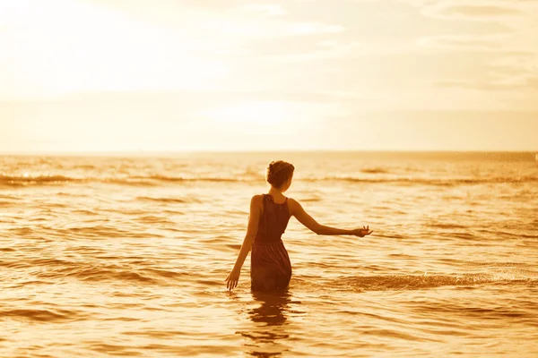 Γυναίκα στην παραλία το ηλιοβασίλεμα. — Φωτογραφία Αρχείου