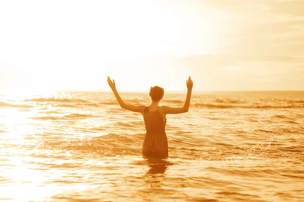 Жінка на пляжі на заході сонця . — стокове фото
