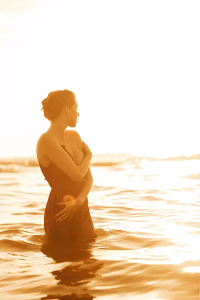 日没時にビーチで女性が. — ストック写真