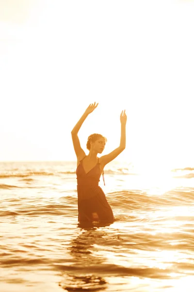 Nő a strandon naplementekor. — Stock Fotó