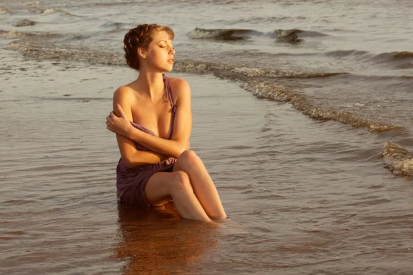 Mulher na praia ao pôr do sol. — Fotografia de Stock