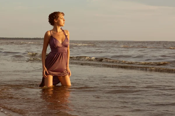 Mulher na praia ao pôr do sol. — Fotografia de Stock