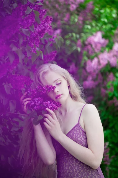 Vrouw met een lila bloemen. — Stockfoto