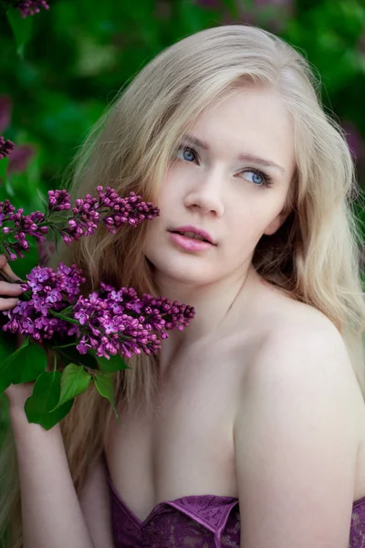 Vrouw met een lila bloemen. — Stockfoto
