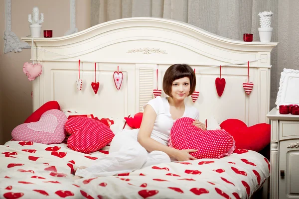 Kadın yatakta kalpleri ile — Stok fotoğraf