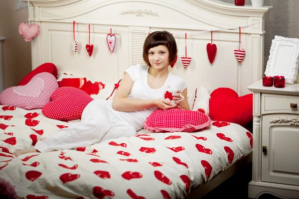 Žena v posteli se srdíčky — Stock fotografie