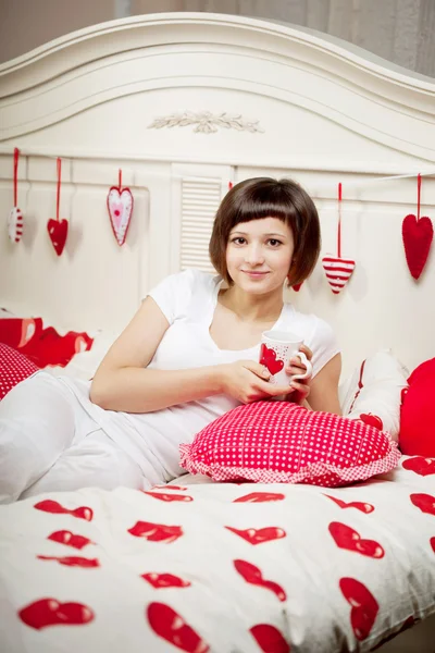 Kobieta w łóżku z serca — Zdjęcie stockowe