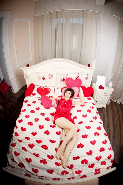 Женщина в постели с сердцами — стоковое фото