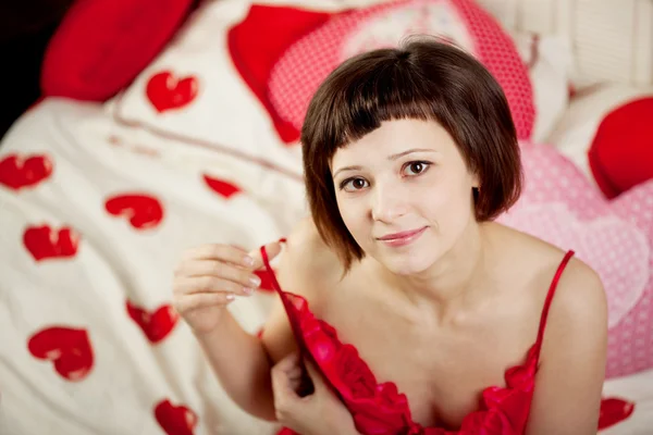 Kvinna i sängen med hjärtan — Stockfoto
