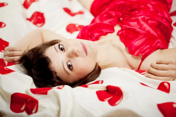 Mujer en la cama con corazones — Foto de Stock