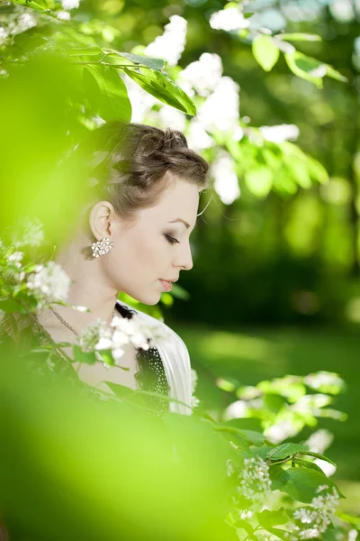 Žena s vlasy COP v kvetoucí park. — Stock fotografie
