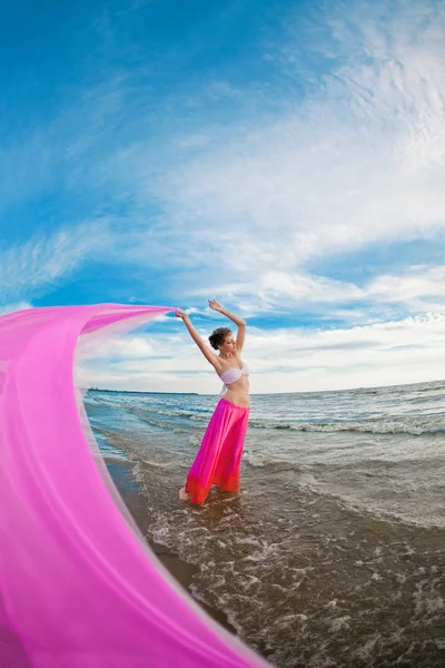 Femme avec un mouchoir dans les mains sur la plage Photo De Stock