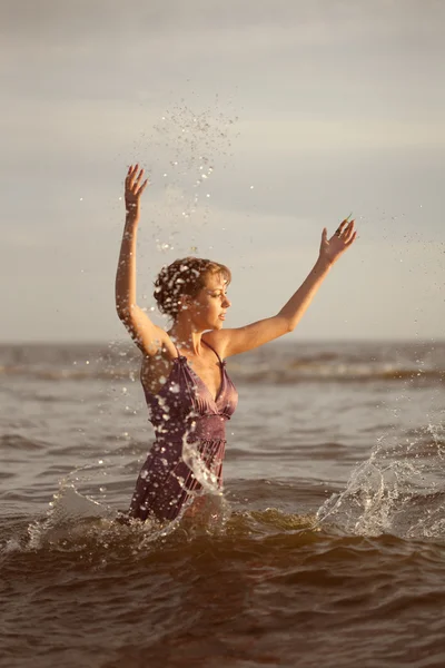 Žena na pláži při západu slunce. Royalty Free Stock Obrázky