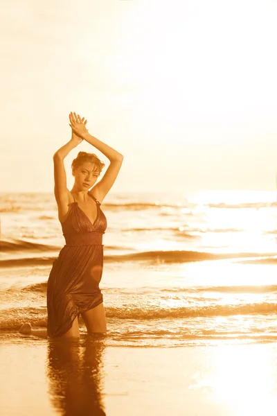 Žena na pláži při západu slunce. Stock Snímky