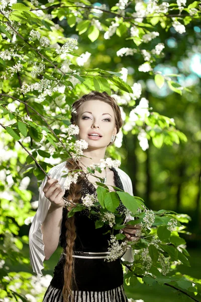 Женщина с косой в цветущем парке . Стоковое Изображение