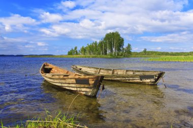 Two boats on the lake on blue sky background clipart