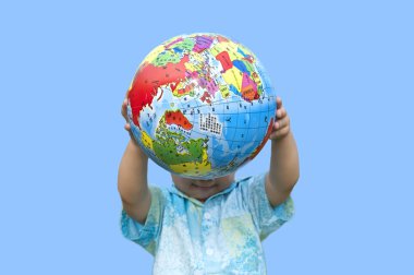 Boy holding the earth model under blue sky clipart