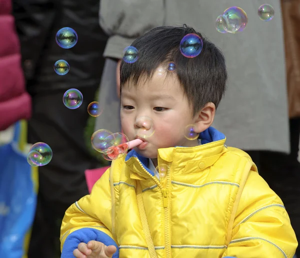 Criança soprando bolhas de sabão — Fotografia de Stock