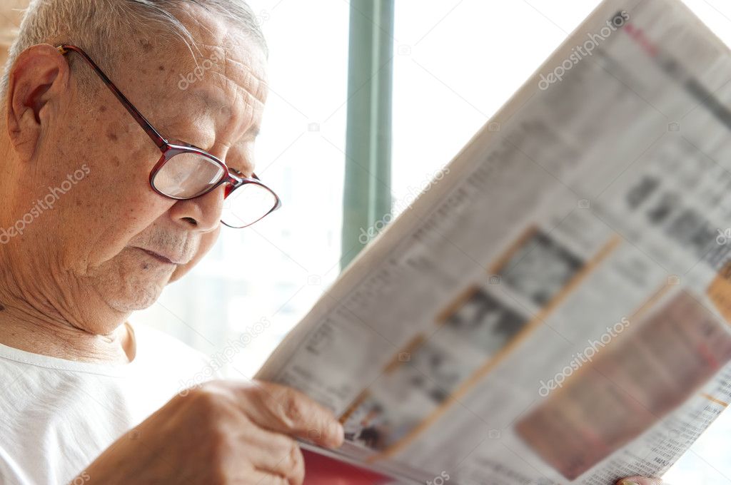A senior man is reading newspaper
