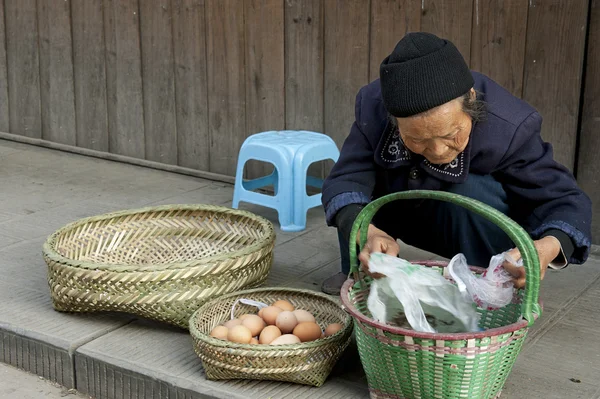 Una donna vende uova in una città — Foto Stock