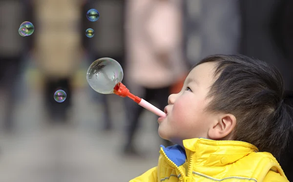 Dítě fouká mýdlové bubliny — Stock fotografie
