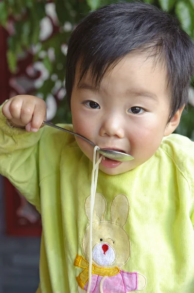 Um bebê bonito está comendo no restaurante — Fotografia de Stock