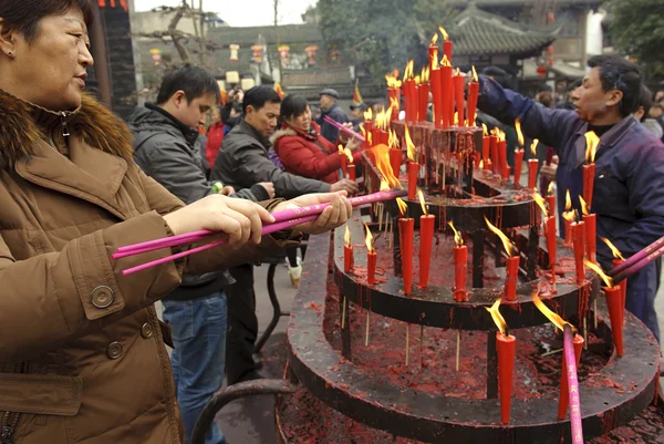 A woman burning incense upon the incense altar in temple — Stock Photo, Image