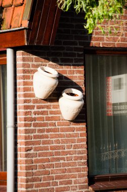 Two clay jars on bricks wall