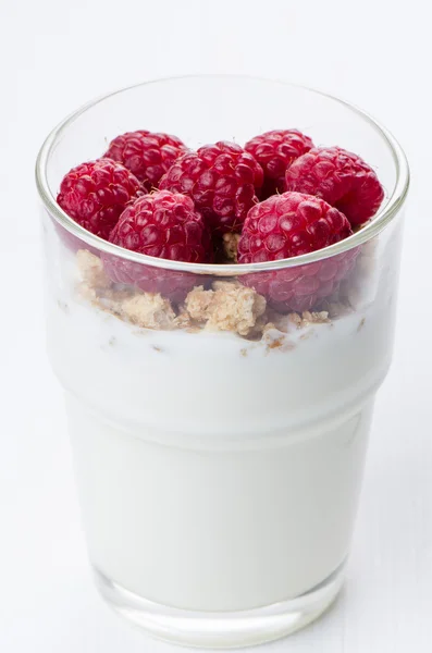 Yogurt con lamponi in un bicchiere su sfondo bianco — Foto Stock