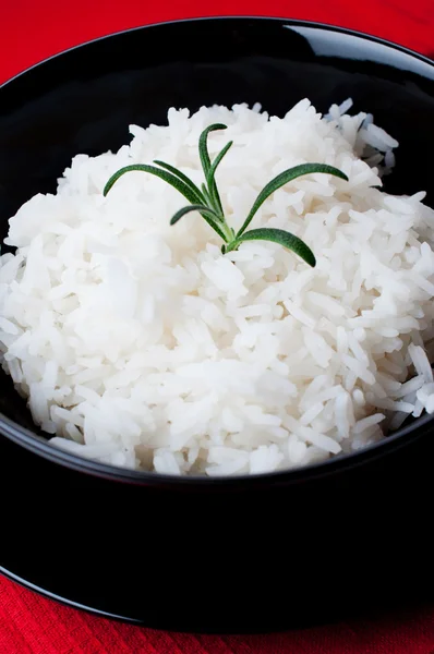 Witte rijst in zwarte kom op rood tafellaken — Stockfoto