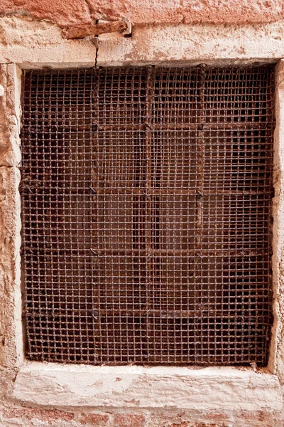 Vecchia finestra in maglia rustica sul muro di Venezia — Foto Stock