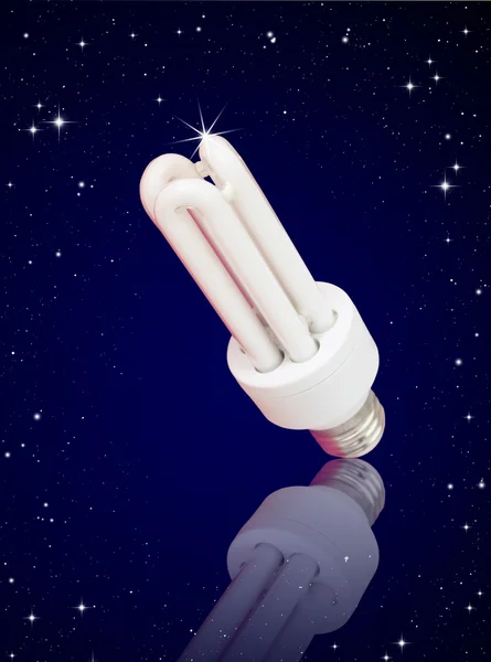 Компактная флуоресцентная лампочка на фоне ночного неба — стоковое фото