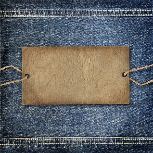 Background denim texture with cardboard label — Stock Photo, Image