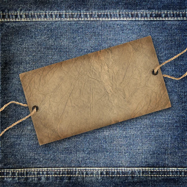 Background denim texture with cardboard label — Stock Photo, Image