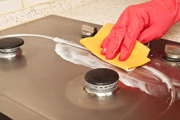 Человек чистит газовую плиту — стоковое фото