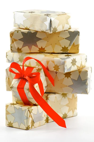 Pila de cajas de regalo y una con arco rojo — Foto de Stock