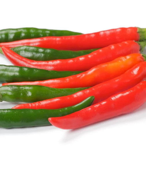 Arrangement of green and red chili peppers — Stock Photo, Image