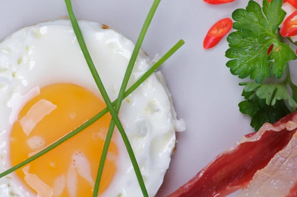 Смажені яйця сонячній стороні з беконом, петрушка і салат — стокове фото