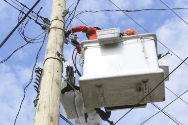 Two Linemen in a Cherry Picker clipart