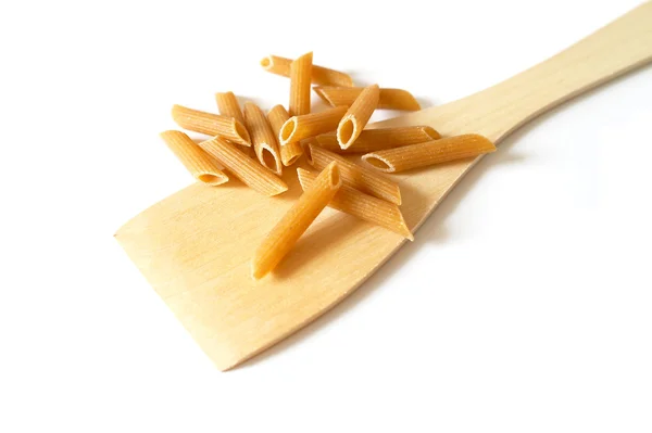 Uncooked pasta selection with a wooden spoon — Stock Photo, Image
