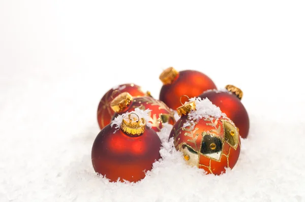Bugigangas vermelhas de Natal na neve — Fotografia de Stock