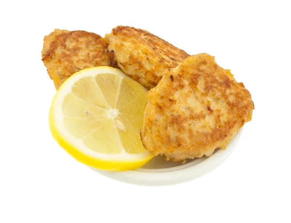 Costeletas de peixe com um limão no prato branco . — Fotografia de Stock