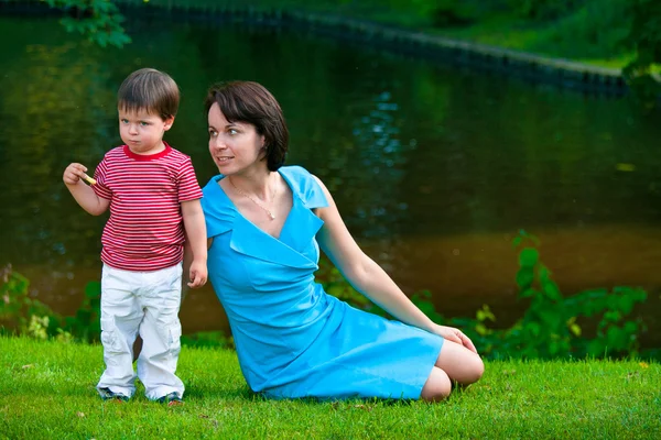 Ładny dwóch lat chłopiec z jego młoda mama w parku — Zdjęcie stockowe