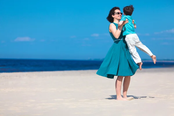 Moeder en haar zoontje spelen op het strand — Stockfoto
