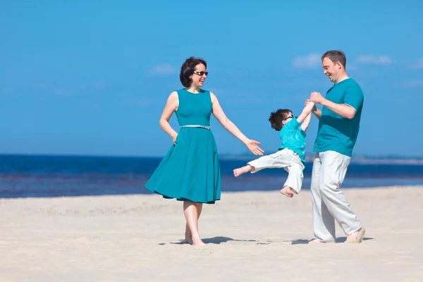 Família de três se divertindo na praia — Fotografia de Stock
