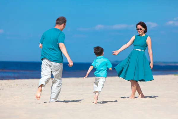 Giovane famiglia di tre divertendosi spiaggia tropicale — Foto Stock