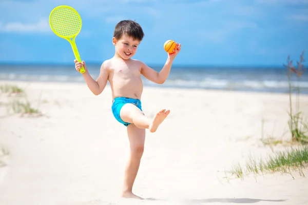 Glad liten pojke spelar på tropical beach — Stockfoto