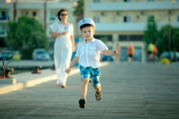 Kleiner Junge und seine Mutter rennen am Steg — Stockfoto