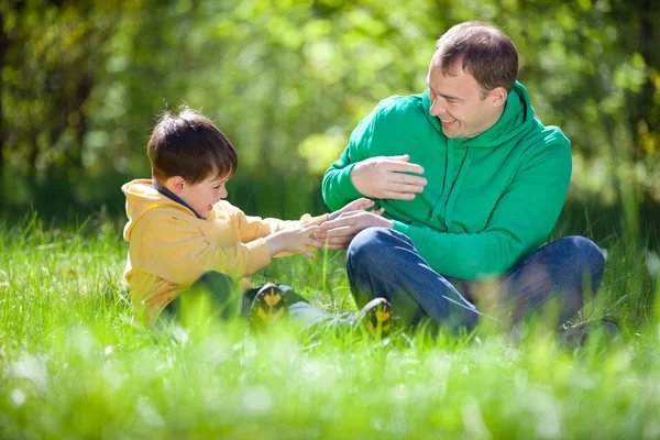 Szczęśliwy ojciec gra z synkiem na zewnątrz — Zdjęcie stockowe